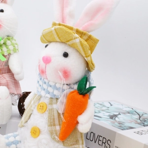 Conejos de Pascua de peluche luminosos con cuadros y zanahorias sobre fondo blanco