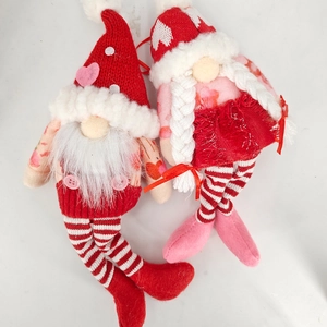 Close-up of handmade Valentine's Day plush gnomes with heart patterns and soft knitted hats