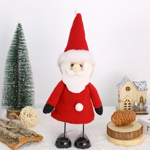 Detail of plush Santa figurine with red knit hat and white beard on festive background