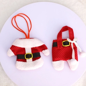 Set de porte-couverts en forme de vêtements de Noël sur un plateau avec fond en peluche
