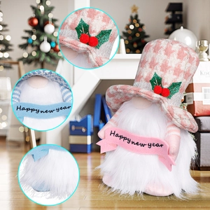 Pink gnome plush Christmas decoration holding Happy New Year banner in festive home setting
