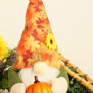 Harvest gnome doll holding an orange pumpkin with maple leaf hat and sunflower detail