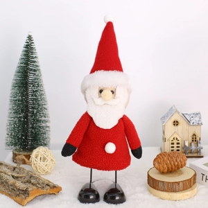 Plush Santa Claus figurine with spring legs standing on white snow mat with Christmas decor