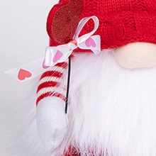 Gros plan d'un gnome de la Saint-Valentin avec bonnet rouge, nœud à cœurs et barbe duveteuse