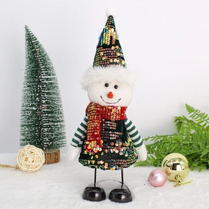 Détail d'une poupée de Noël aux paillettes vertes avec des ornements festifs