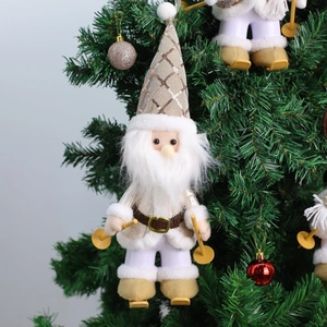 Detail view of a plush Santa Claus ornament with silver sequins on a Christmas tree