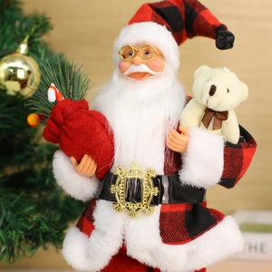 Standing Santa Claus figure in red plaid outfit with teddy bear and gift bag ornament