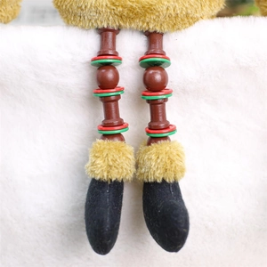 Close-up of decorative Christmas doll legs with festive colorful rings and yellow plush detail