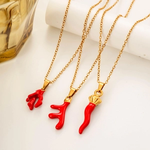 Colliers en acier doré avec pendentifs en émail rouge présentés sur socles blancs