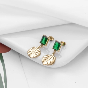 Elegant gold leaf earrings with emerald green zircon gemstone on a minimal white background