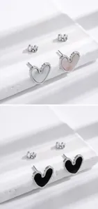 Detail of heart-shaped stainless steel stud earrings with shell and black enamel inlay
