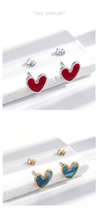 Detail of heart earrings in red silver and blue gold marble on a minimalist stone base