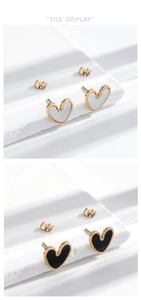Detail view of heart-shaped earrings with black and white enamel on stone blocks