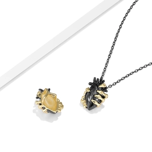 Gotische anatomische hartketting vastgehouden door gouden skelethanden in zwart S925 zilver