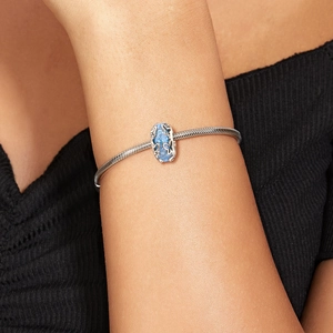 Blue butterfly glass charm in S925 sterling silver worn on a snake chain bracelet