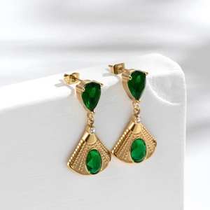 Elegant gold-plated fan-shaped drop earrings with deep green stones on a stone pedestal