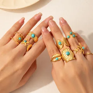 Primo piano di anelli boho a forma di stella marina e conchiglia con turchese