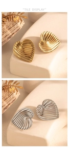 Détail de boucles d'oreilles plissées en forme de cœur en or et argent sur socle