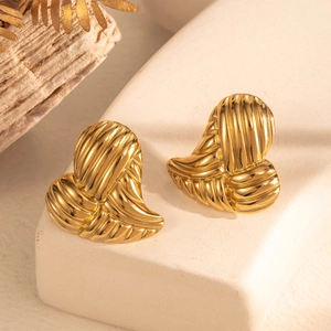 Boucles d'oreilles cœur dorées avec texture nervurée sur socle en pierre blanche