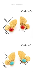 Detail view of gold butterfly wing earrings with red and turquoise stone inlay