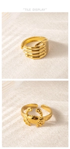 Detalle de anillos hip-hop dorados con diseños de cangrejo y manos entrelazadas