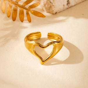 Minimalist gold heart-shaped open ring made of polished stainless steel on a stone base