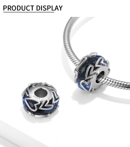 Macro shot of S925 sterling silver hollow heart charm with deep blue glass bead