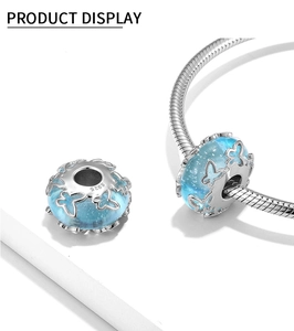 Macro shot of S925 silver butterfly glass charm with light blue glitter effect