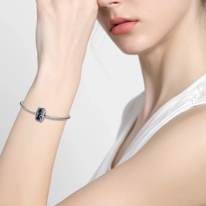 S925 sterling silver heart bead bracelet on wrist with deep blue glass charm