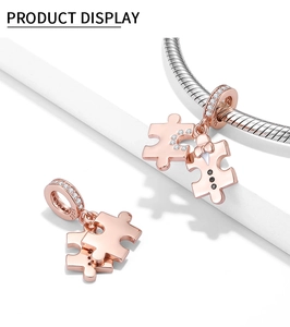 Close-up of rose gold puzzle charms in S925 silver with moon and bow tie details