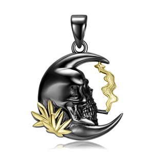 Detail of gothic silver moon pendant with realistic skull and golden leaf accents