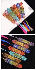 Detail of seven chakra resin bookmarks with natural crystals and golden sacred geometry