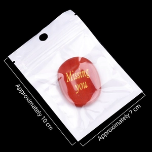 Red oval natural crystal stone with Missing you engraving in a clear package