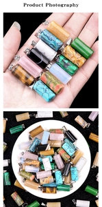 Macro shot of assorted colorful cylindrical natural stone pendants in a white ceramic dish