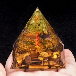 Pyramide Orgone Arbre de Vie en Péridot et Oeil de Tigre tenue en main pour décoration
