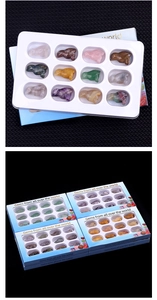 Macro detail of 12 natural semi-precious stones with animal carvings in a blue display box