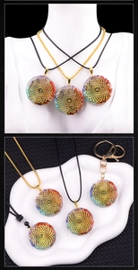 Gros plan d'un pendentif Orgonite avec pierres de chakra et insert en métal mandala doré