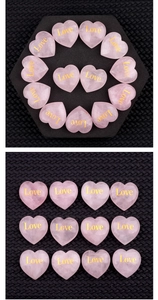 Macro shot of rose quartz crystal heart featuring a gold-engraved Love inscription