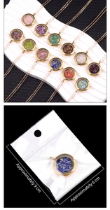 Detail of round stainless steel locket necklace filled with natural crystal quartz stones