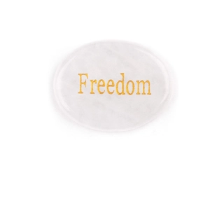 Pierre de cristal blanc polie avec gravure Freedom dorée sur fond blanc neutre