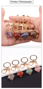 Detail of natural crystal resin pyramid keychain with golden lobster clasp and key ring
