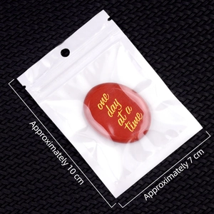 Red agate palm stone engraved with One Day at a Time in protective white packaging