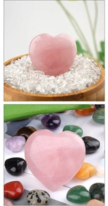 Close-up of polished natural pink rose quartz heart stone in a wooden bowl with white crystals