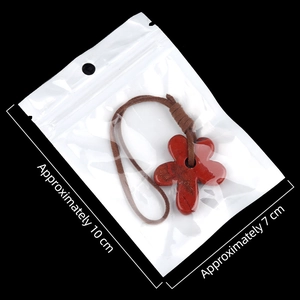 Red flower pendant carved from natural stone with a brown cord in transparent packaging