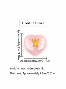 Dettaglio di cuore in quarzo rosa con lettera W dorata e trama in cristallo naturale