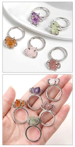 Detailed comparison of various raw natural crystal rings shown in hand for size scale