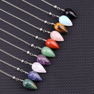 Multiple teardrop crystal pendants for yoga meditation on black textured background