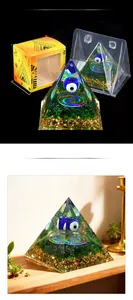 Detailed view of evil eye orgone pyramid with green stone chips and packaging box