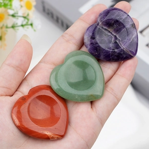 Polished heart worry stones in amethyst green aventurine and red jasper held in hand