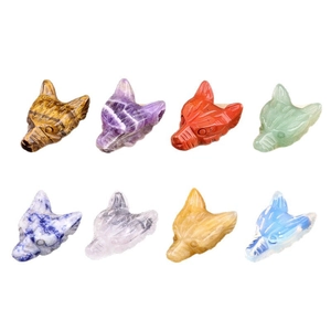 Set of 8 natural crystal wolf head carvings in various gemstones on a white background